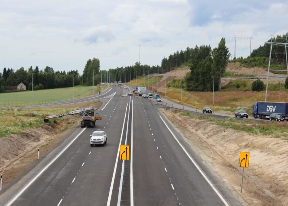The newly expanded Vt6 Taavetti-Lappeenranta four-lane motorway in South Karelia, Finland, nearing completion with construction vehicles and traffic visible on the freshly paved road.